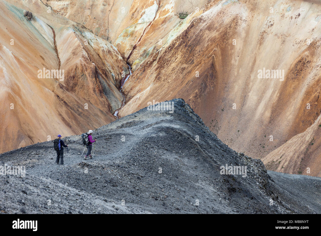 Gli escursionisti Decending la montagna di Blahnukur con la riolite piste colorate di Brennisteinsalda avanti, Landmannalaugar Islanda Foto Stock