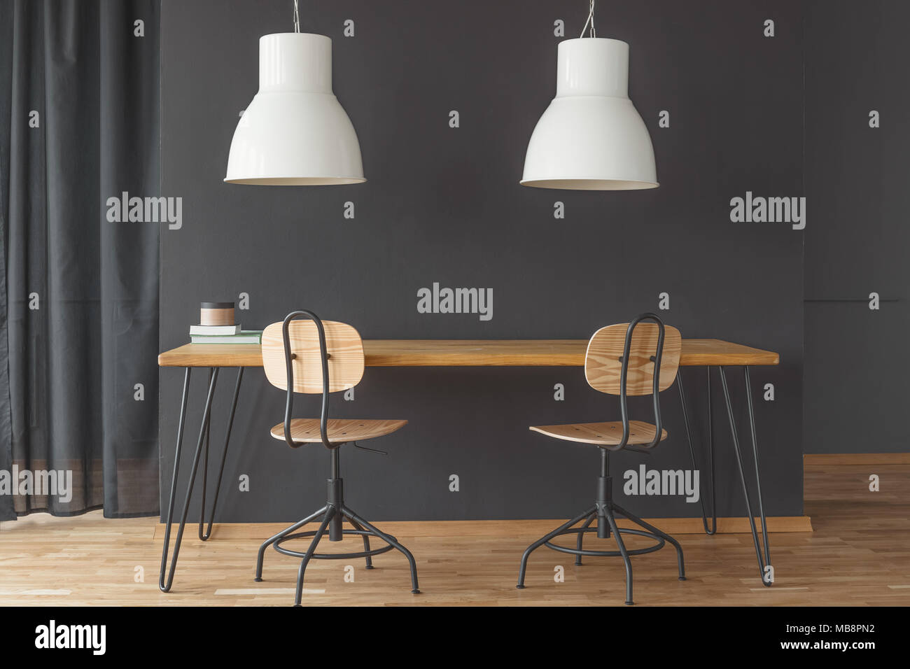Due luci bianche appeso sopra la tabella a forcina in nero sala da pranzo interno con tenda e sedie Foto Stock