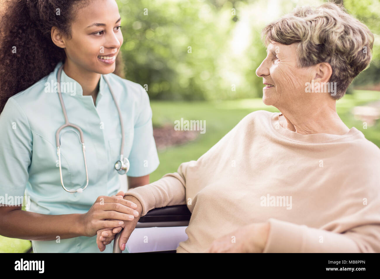 Senior donna e il suo medico di trascorrere del tempo nel giardino al di fuori dell'ospedale Foto Stock
