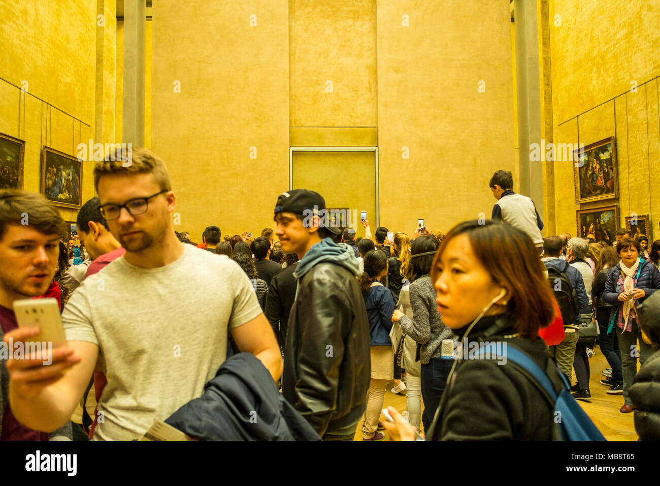 I turisti cercando di ottenere un assaggio di Leonardo la Mona Lisa di Leonardo da Vinci presso il Museo del Louvre, Francia Foto Stock