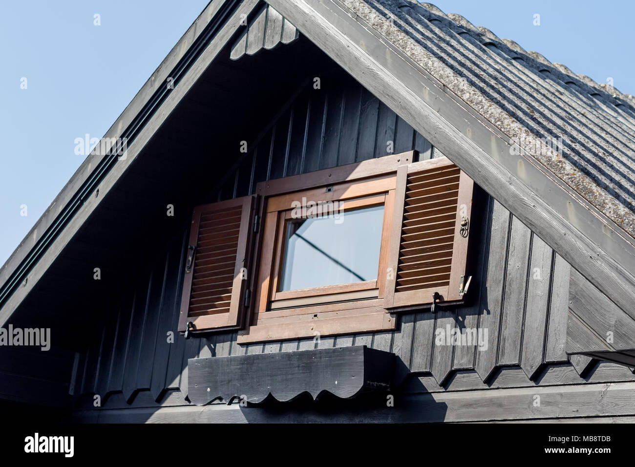 Rustico nero piastrelle di legno del tetto cabina e il finestrino Foto Stock