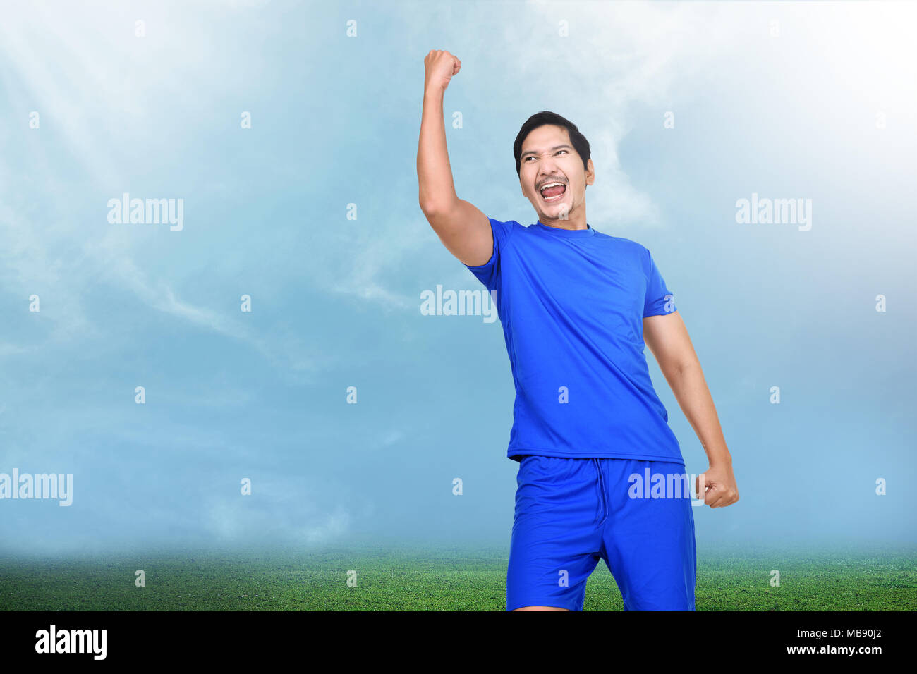 Emozionato asian giocatore di football con felice festa sul campo dello stadio Foto Stock