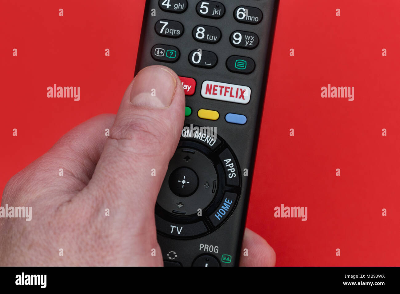 Londra - Aprile 06, 2018: la mano che tiene la televisione telecomando con pulsante di Netflix Foto Stock
