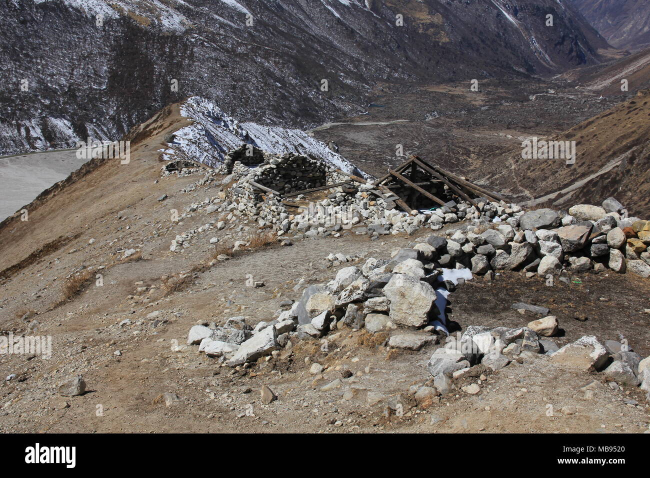 In scena la Langtang National Park, Nepal. Scoperchiata capanne in pietra su un crinale. Foto Stock
