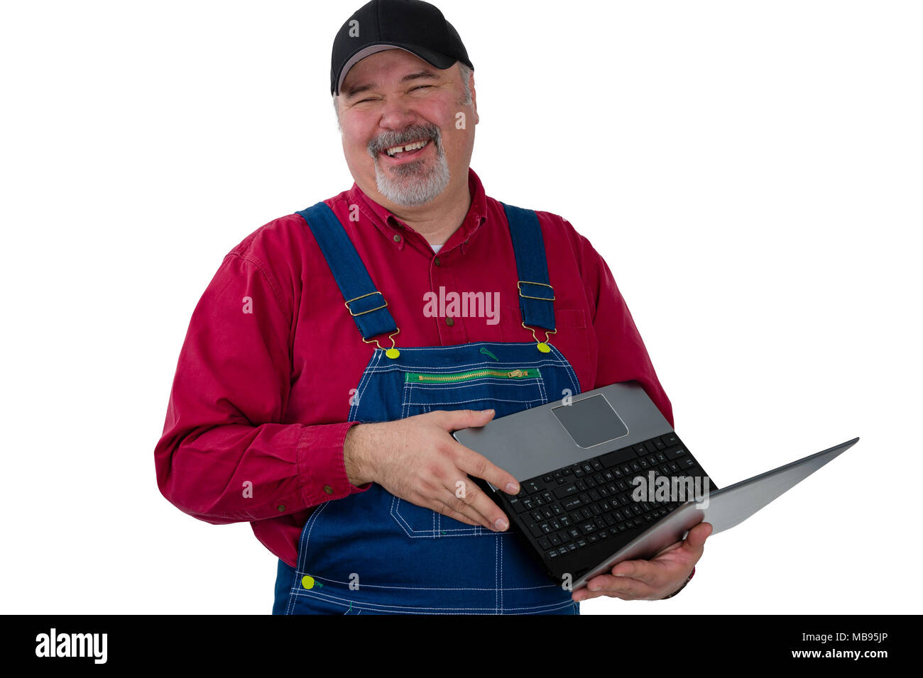 Ridendo geniale lavoratore o imprenditore che indossa jeans salopette da azienda permanente di un laptop aperto, la parte superiore del corpo ritratto isolato su bianco Foto Stock