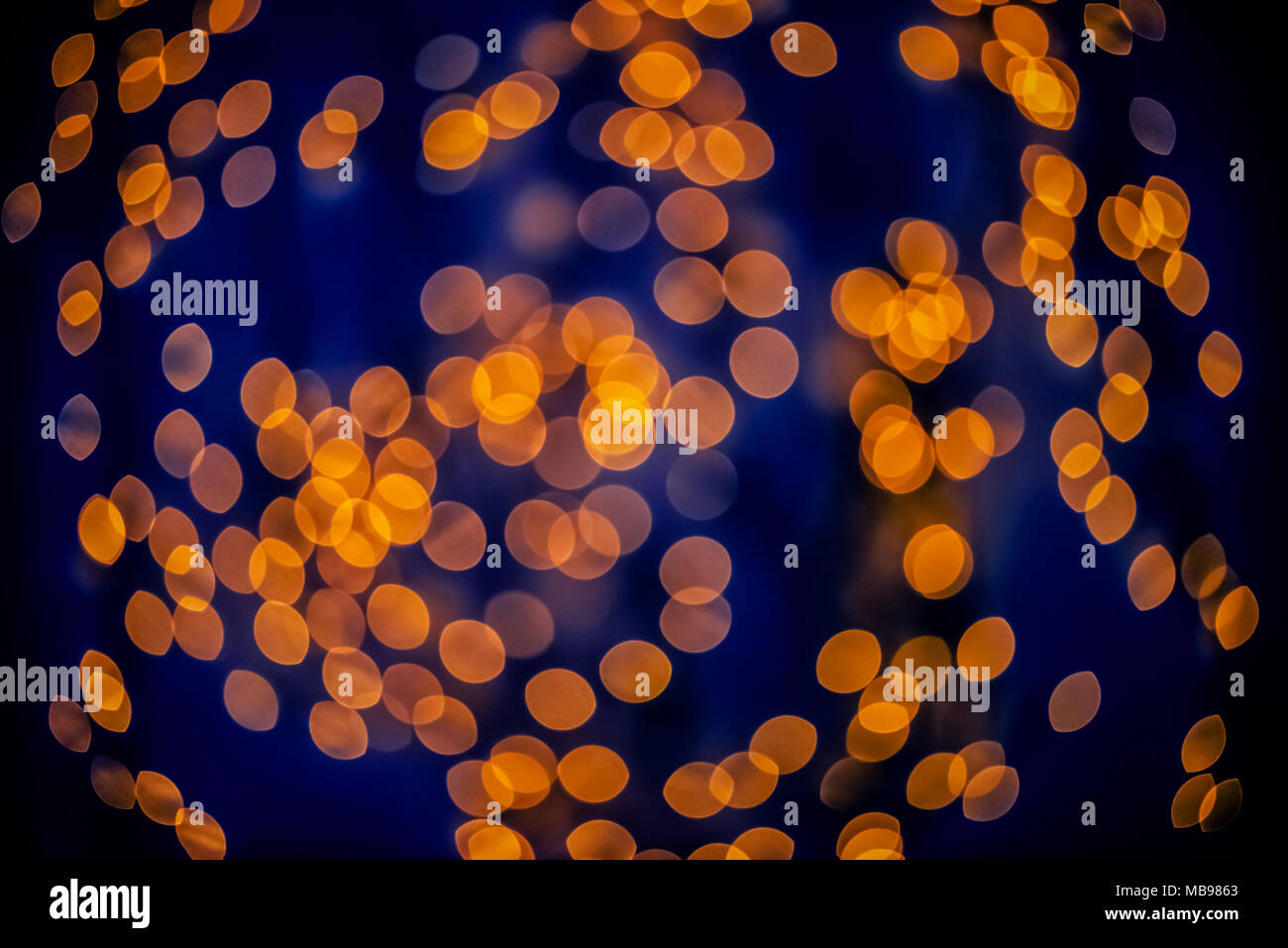 Sfondo bokeh incandescente di forma ovale bagliore arancione scuro e blu scuro vuoto Foto Stock