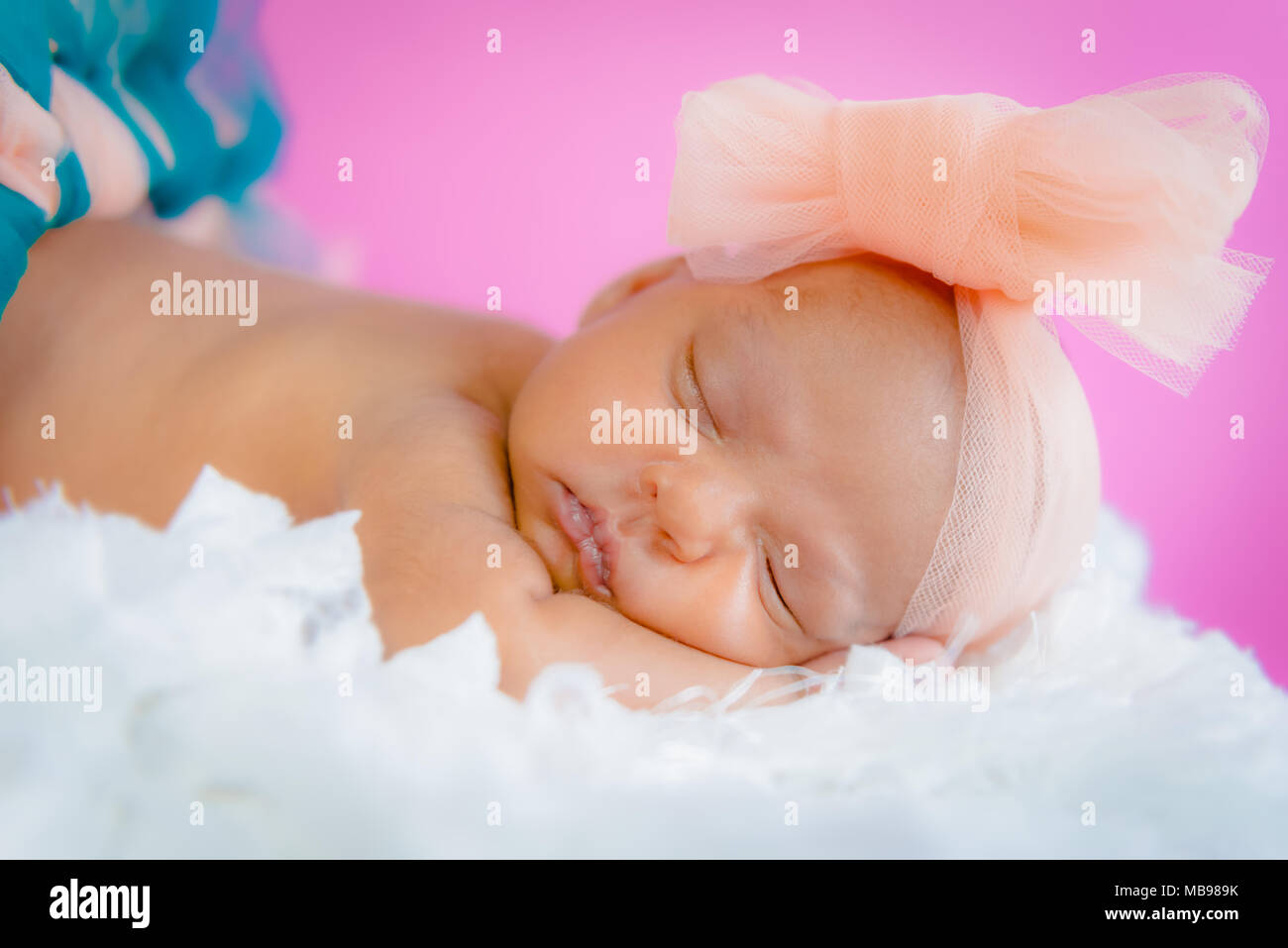 Quattro settimane bambino neonato ragazza foto studio dormire su soffici cuscini indossando tutu e bow closeup Foto Stock