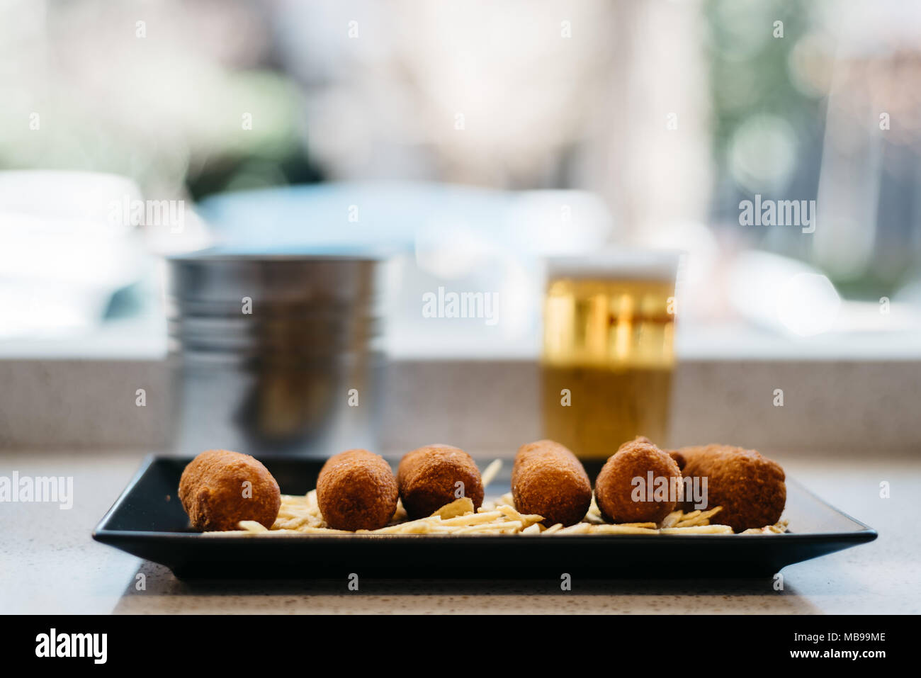 Close up di crocchette di patate con la birra in background. La messa a fuoco in primo piano Foto Stock