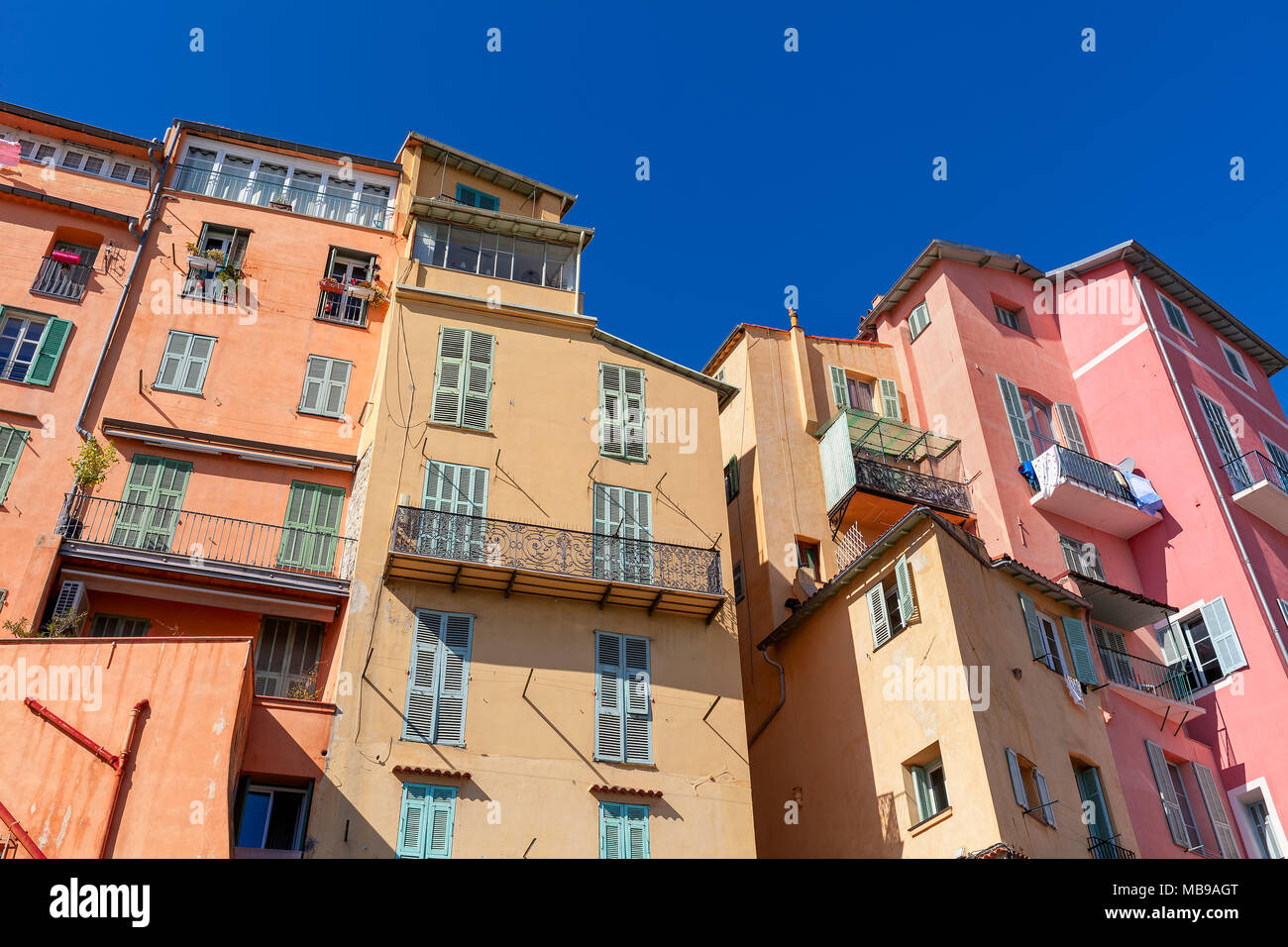Vista di colorate case residenziali sotto il cielo blu nella piccola città di Menton, Francia. Foto Stock