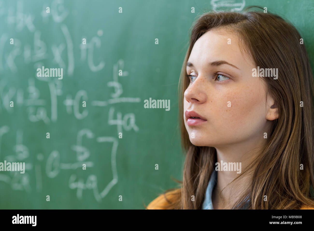 Ragazza adolescente in classe math sopraffatti dalla formula di per la matematica. Pressione, istruzione, concetto di successo. Foto Stock