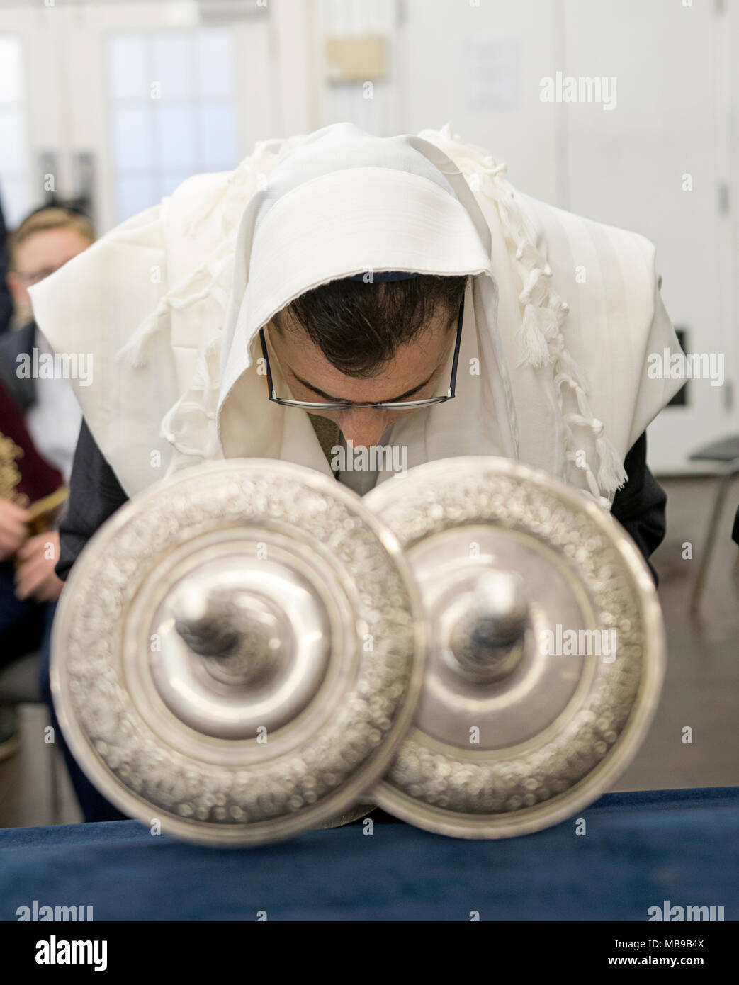 Un ebreo ortodosso uomo in uno scialle rituale recita una benedizione quando viene chiamato alla Torah nella Pasqua ebraica. In Cambria Heights, Queens, a New York Foto Stock