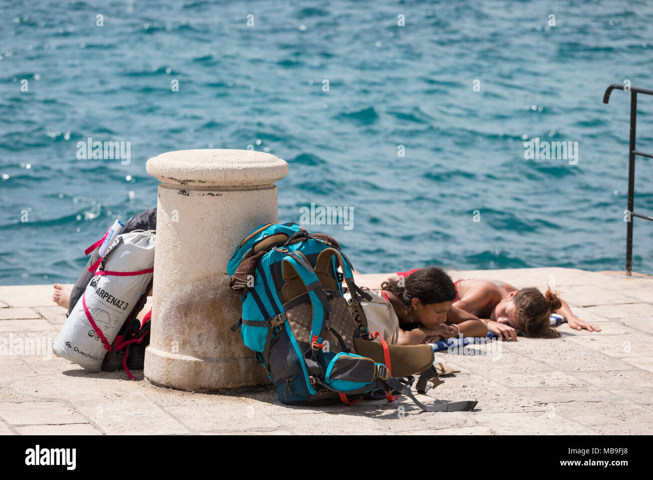 Backpacking ragazze prendendo un po' di riposo in banchina a Zadar, Croazia Foto Stock