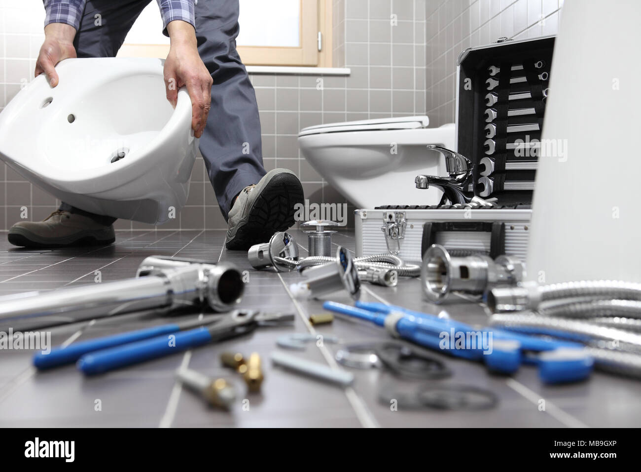 Plumber al lavoro in un bagno, idrosanitari servizio di riparazione, assemblare e installare il concetto Foto Stock