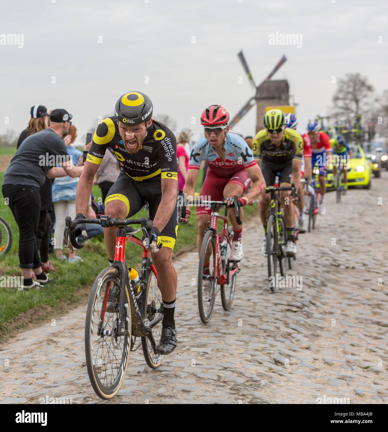 Templeuve, Francia - Aprile 08, 2018: il ciclista francese Adrien Petit di Direct Energie Team a cavallo sulla strada acciottolata in Templeuve davanti alla tradizionale mulino a vento Vertain durante Paris-Roubaix 2018. Credito: Radu Razvan/Alamy Live News Foto Stock