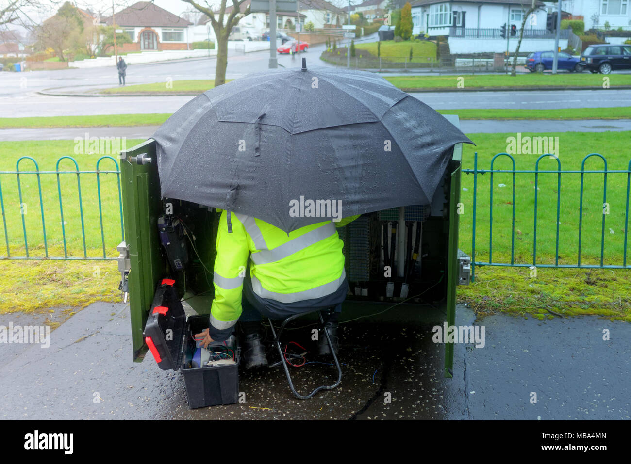 Glasgow, Scotland, Regno Unito il 9 aprile. Meteo REGNO UNITO: si continua a lavorare come un tecnico ripara il sistema telefonico sotto un brolly su un miserabile giorno bagnato con docce squallida. Credito: gerard ferry/Alamy Live News Foto Stock
