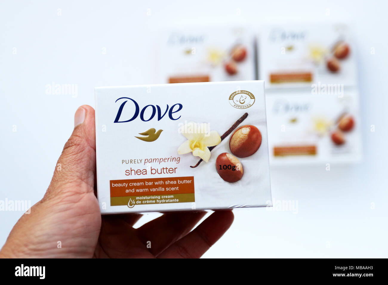Stretta di mano azienda colomba di burro di Karité crema di bellezza una saponetta isolata contro uno sfondo bianco Foto Stock