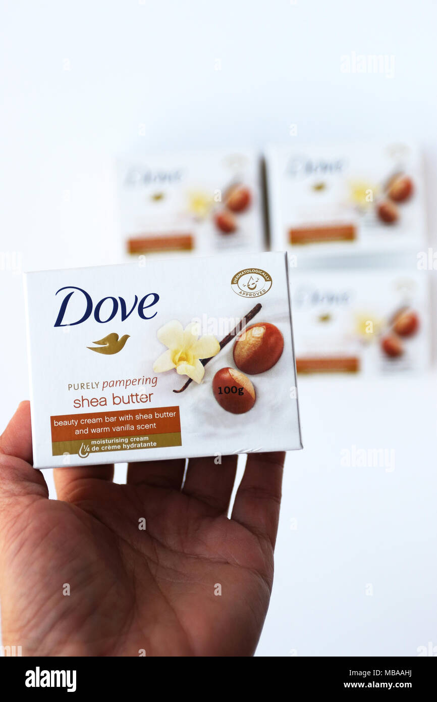 Stretta di mano azienda colomba di burro di Karité crema di bellezza una saponetta isolata contro uno sfondo bianco Foto Stock