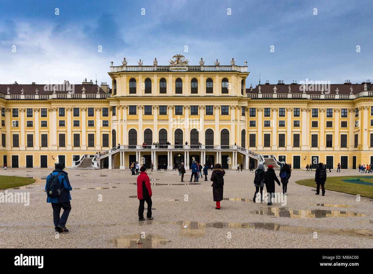 Il parco giardino di Palazzo Shonbrunn (Wien) nella giornata piovosa con piccole pozze e ai grandi gruppi di turisti a piedi attorno a Foto Stock