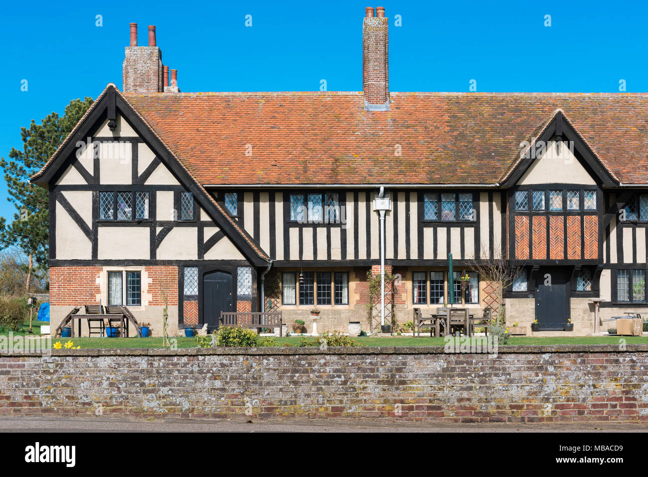 Thorpeness alms case, vista di una fila di case di alms progettato in un Tudor mezzo in legno stile nel centro del villaggio di Thorpeness, Suffolk, Regno Unito Foto Stock