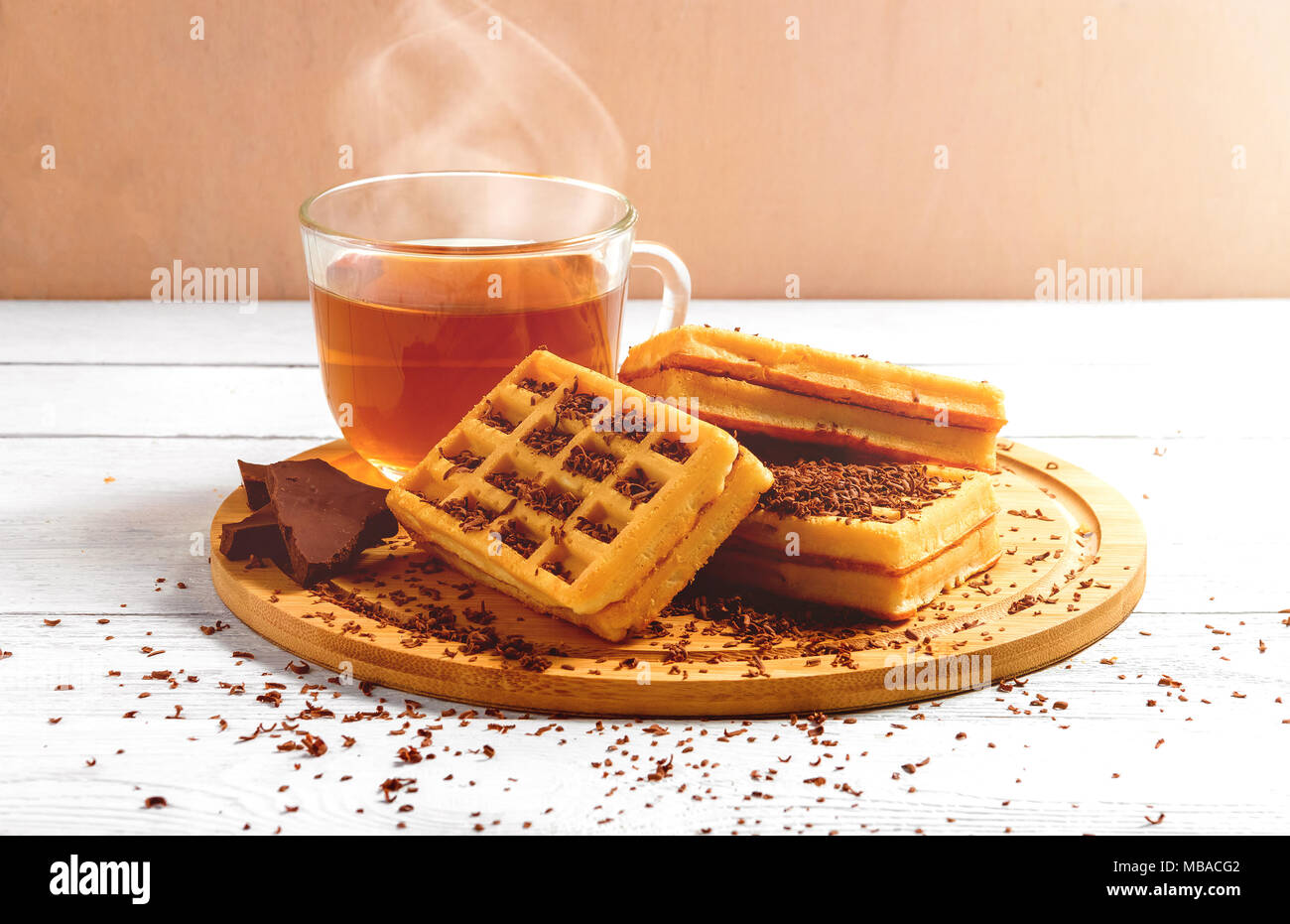 Waffles fatti in casa con la marmellata sul vecchio tavolo in legno. Wafers con tazza di tè, teiera, cioccolato. Foto Stock