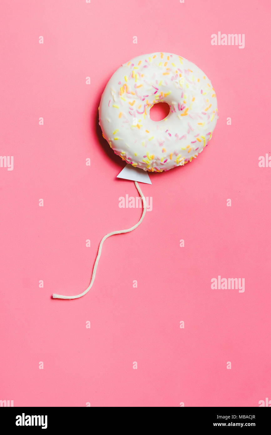 Ciambella in rosa, cucina creativa il minimalismo, la ciambella in forma di palloncino al cielo, vista dall'alto con spazio copia, tonica Foto Stock