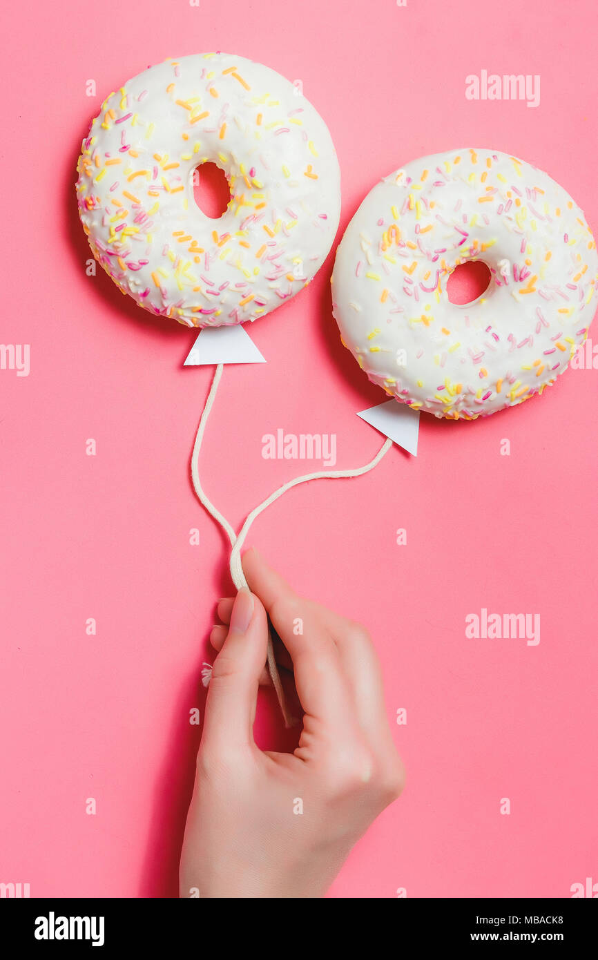 Ciambella in rosa, cucina creativa il minimalismo, la ciambella in forma di palloncino al cielo, vista dall'alto con spazio copia, tonica Foto Stock