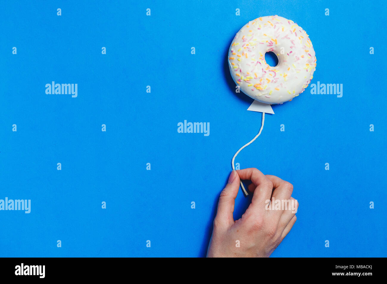 Ciambella sul blu, Cucina Creativa il minimalismo, la ciambella in forma di palloncino al cielo, vista dall'alto con spazio copia, tonica Foto Stock