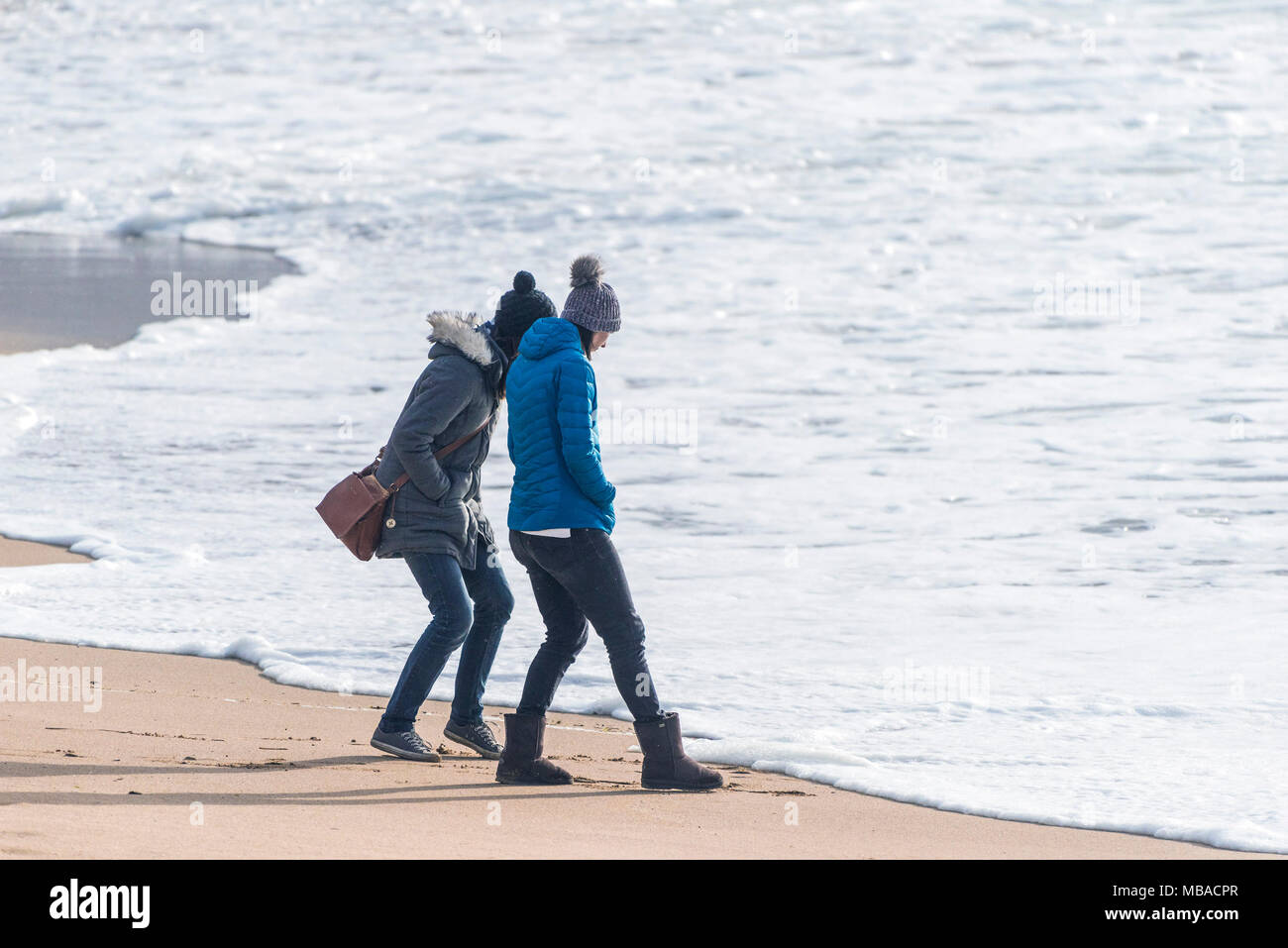 Le donne a guardare la marea su Fistral Beach in Newquay Cornwall. Foto Stock