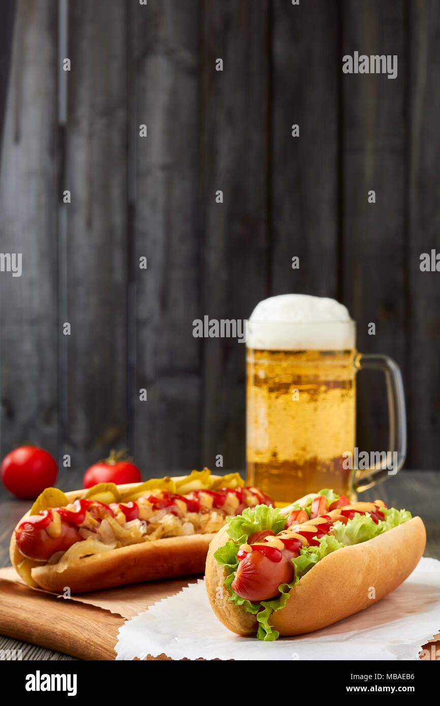 Due hot dogs e bicchiere di birra Foto Stock