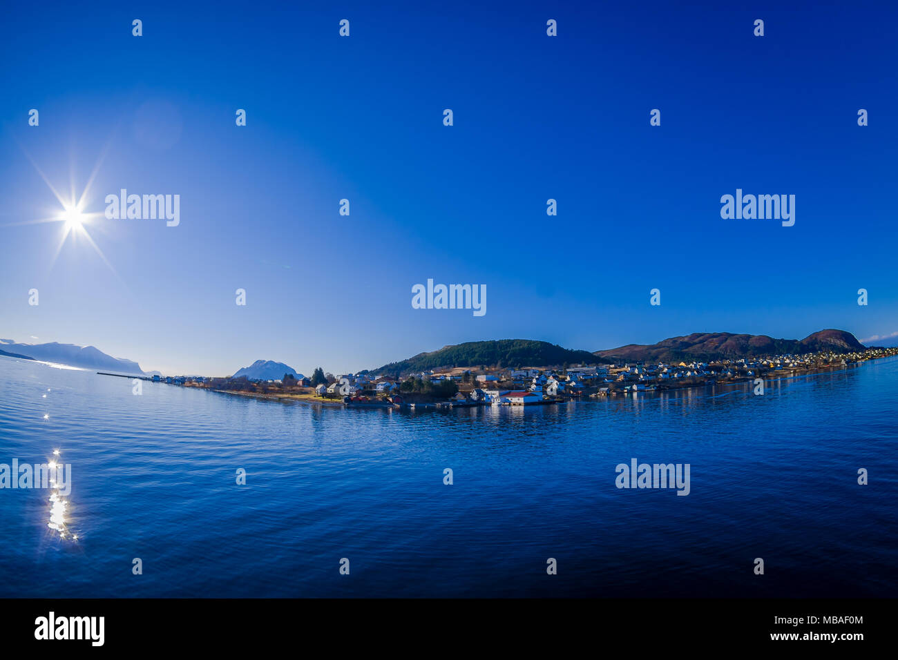 Vista esterna della gamma della montagna in Norvegia. La bellissima montagna nella regione di Hurtigruten con alcuni edifici in horizont in Norvegia Foto Stock