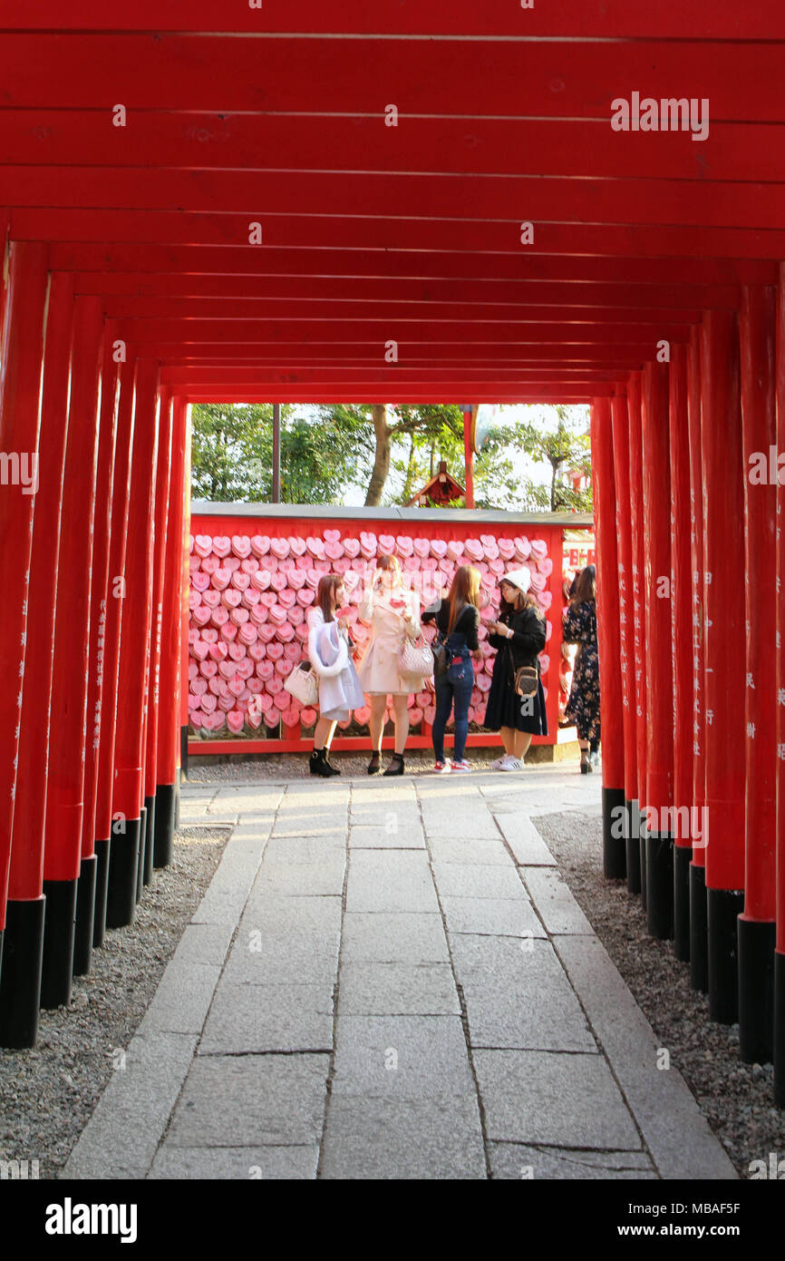 La linea di gate Shinto, e le ragazze prendendo selfie alla fine del tunnel. Prese a Inuyama Santuario, Giappone - Febbraio 2018 Foto Stock