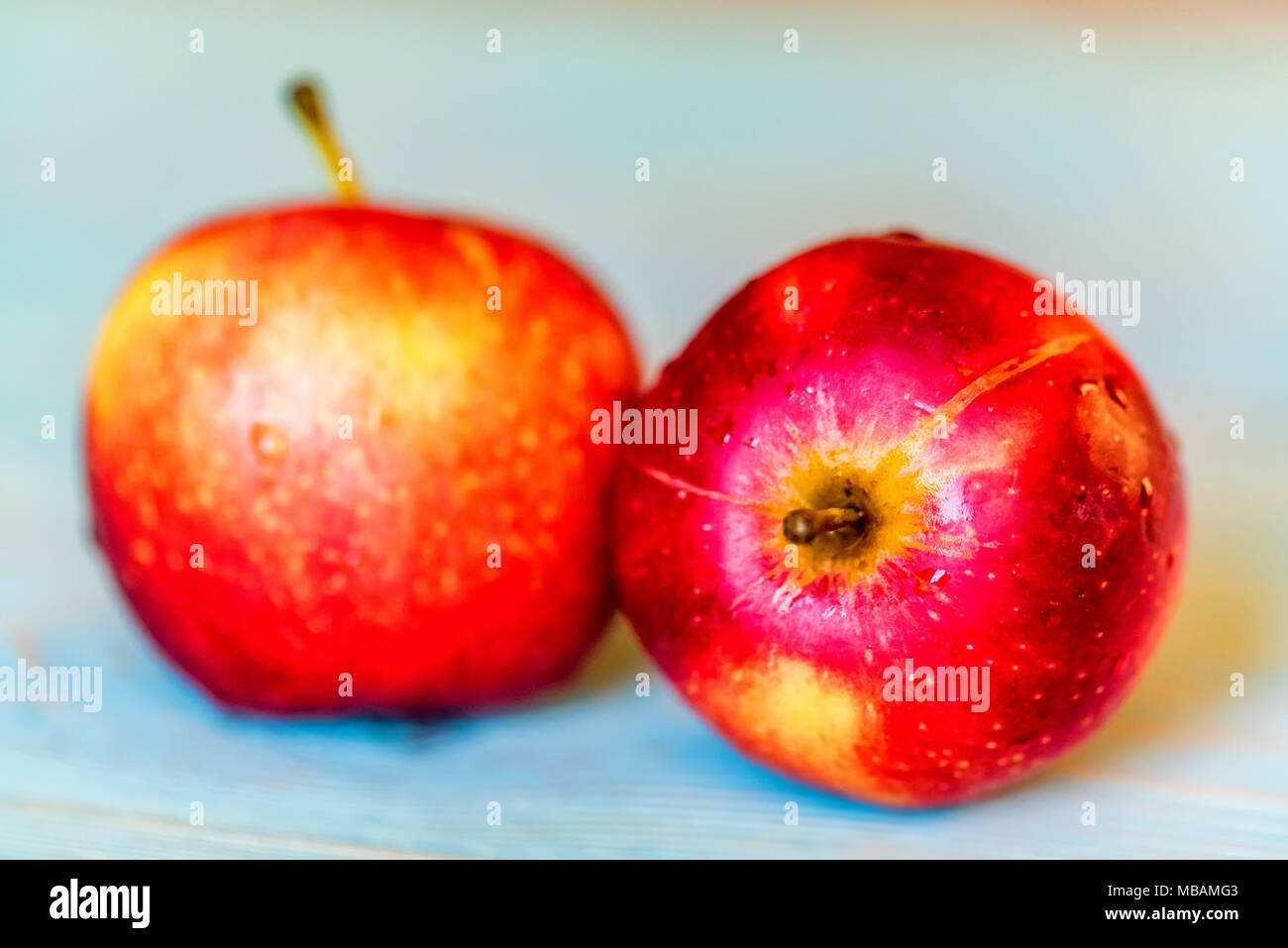 Due interi di mele rosse blu sulla superficie di legno Foto Stock