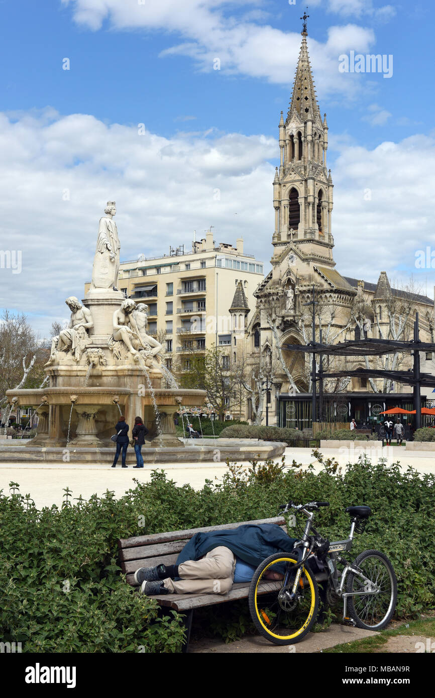 Uomo di dormire su una panchina nel parco Nimes, Francia, 2018 Foto Stock