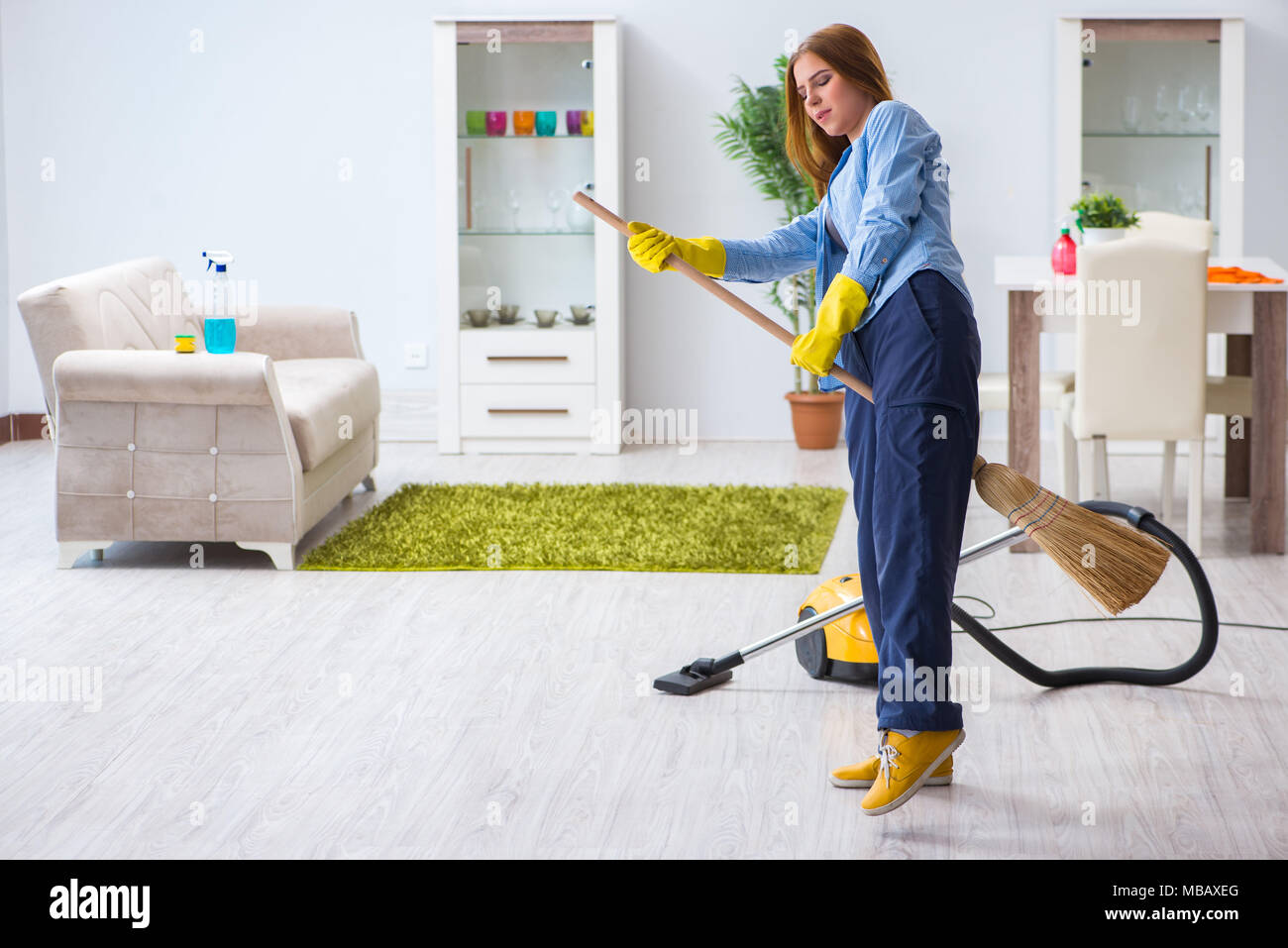 Giovane donna piano di pulizia a casa facendo faccende Foto Stock