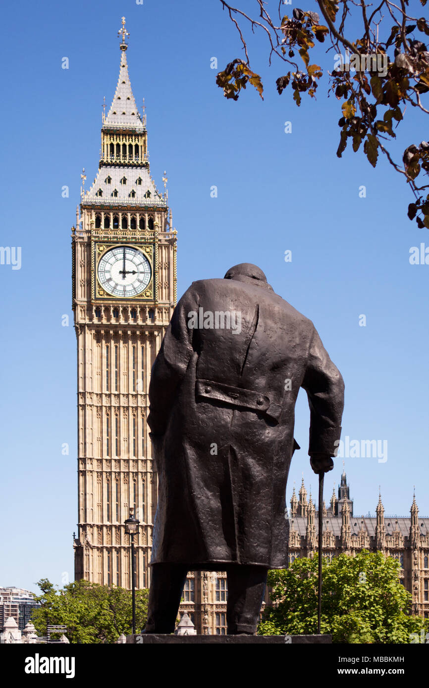 Westminster, Londra. Il Winston Churchill statua in piazza del Parlamento, visto da dietro con il Palazzo di Westminster e il Big Ben in background Foto Stock