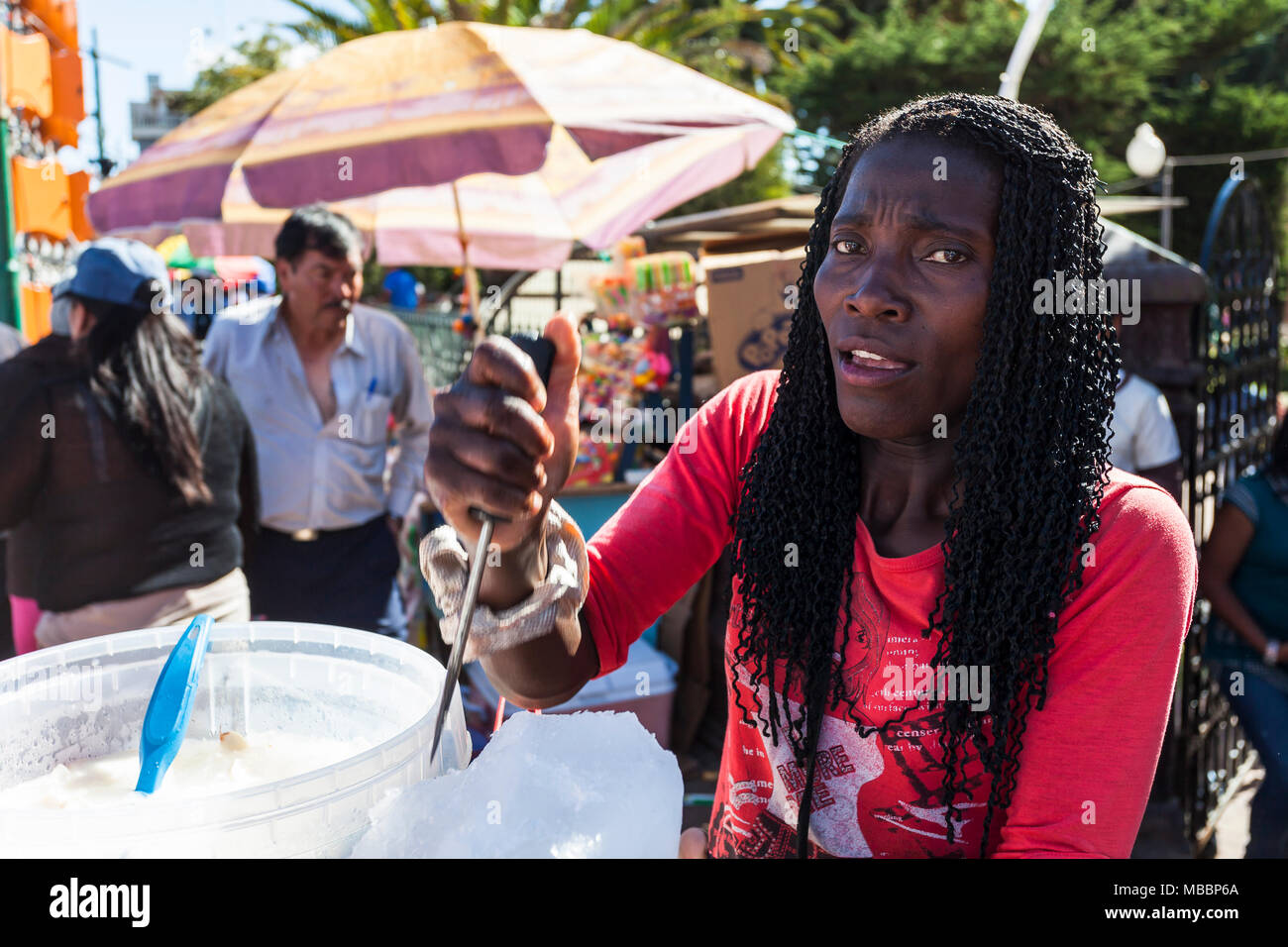 Píllaro, ECUADOR - Febbraio 6, 2016: Unidentified donna vende succo di cocco sulla strada a festa della diabladas di Pillaro Foto Stock