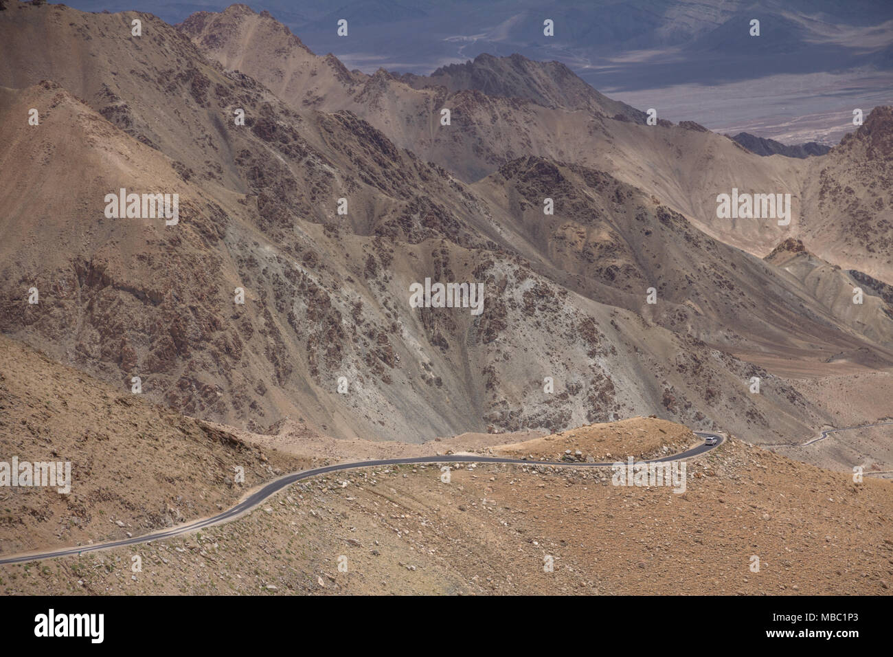 Pieno di tornanti e curve drammatico, la strada a Khardung Pass non è per i deboli di cuore. Non c'è vegetazione di legare le rocce al di sopra e al di sotto. Foto Stock