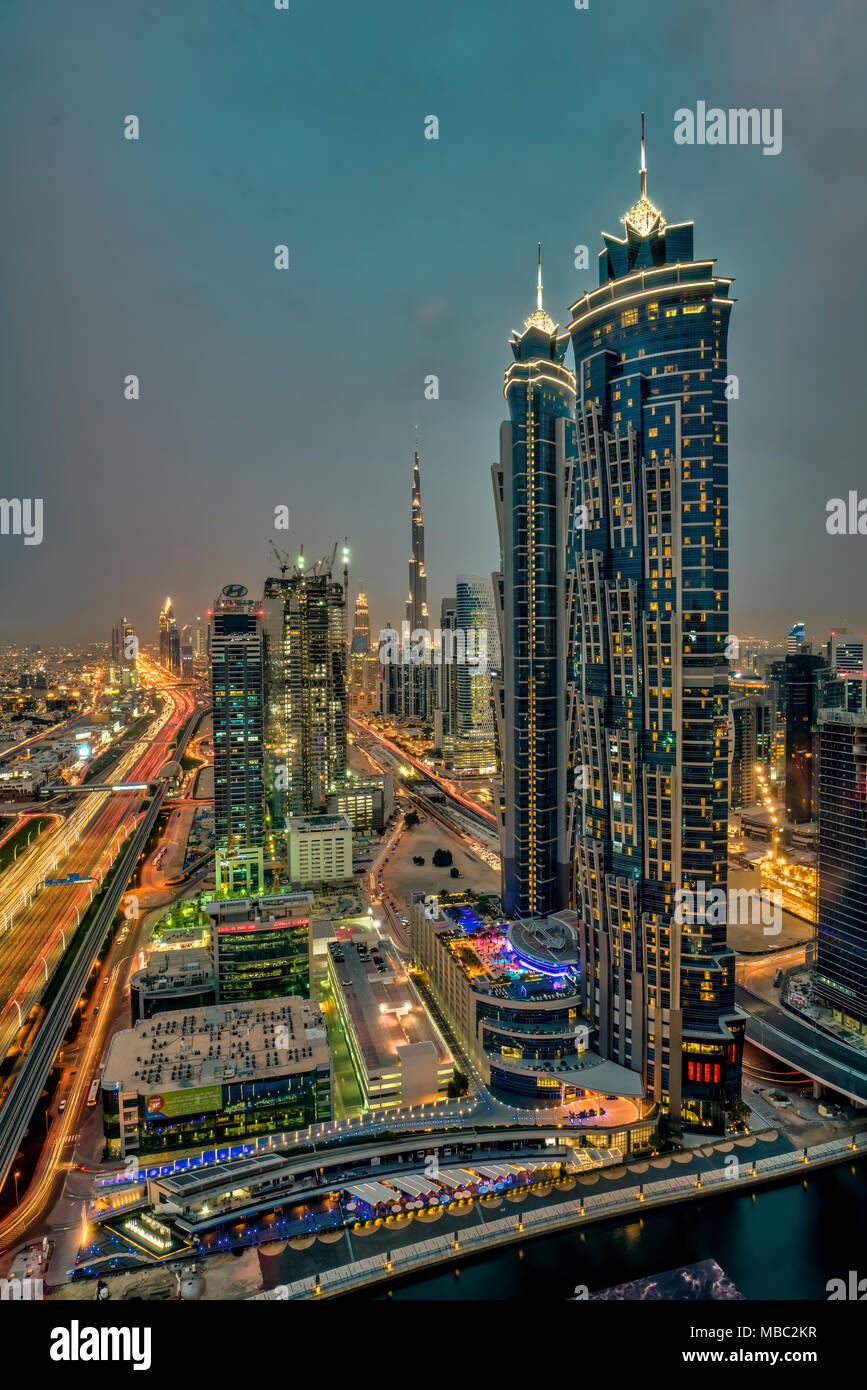 Una vista di edifici alti in Business Bay area illuminata di notte a Dubai, UAE, Medio Oriente. Foto Stock