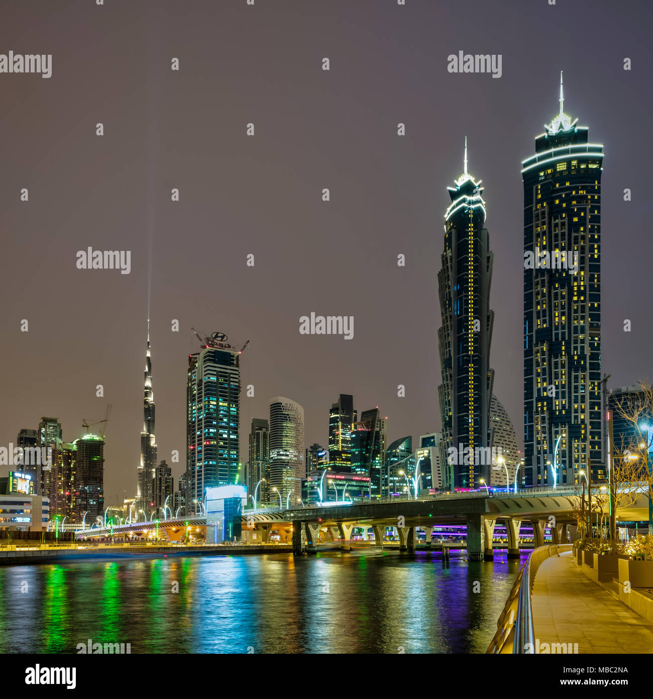 Una vista di edifici alti in Business Bay area illuminata di notte a Dubai, UAE, Medio Oriente. Foto Stock