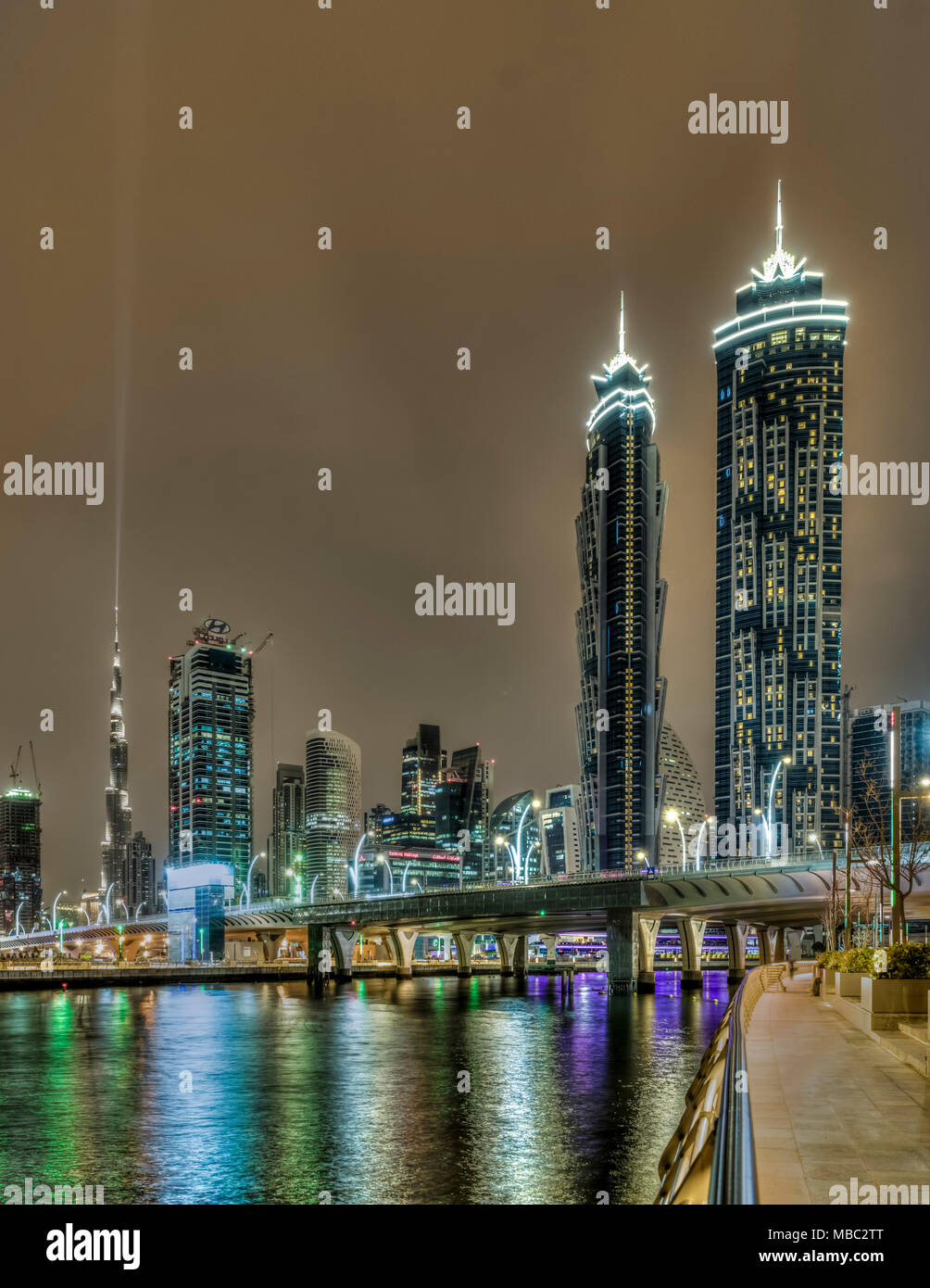 Una vista di edifici alti in Business Bay area illuminata di notte a Dubai, UAE, Medio Oriente. Foto Stock