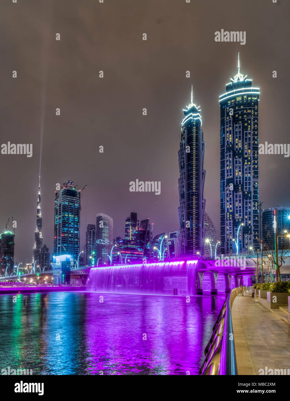Una vista di edifici alti in Business Bay area illuminata di notte a Dubai, UAE, Medio Oriente. Foto Stock