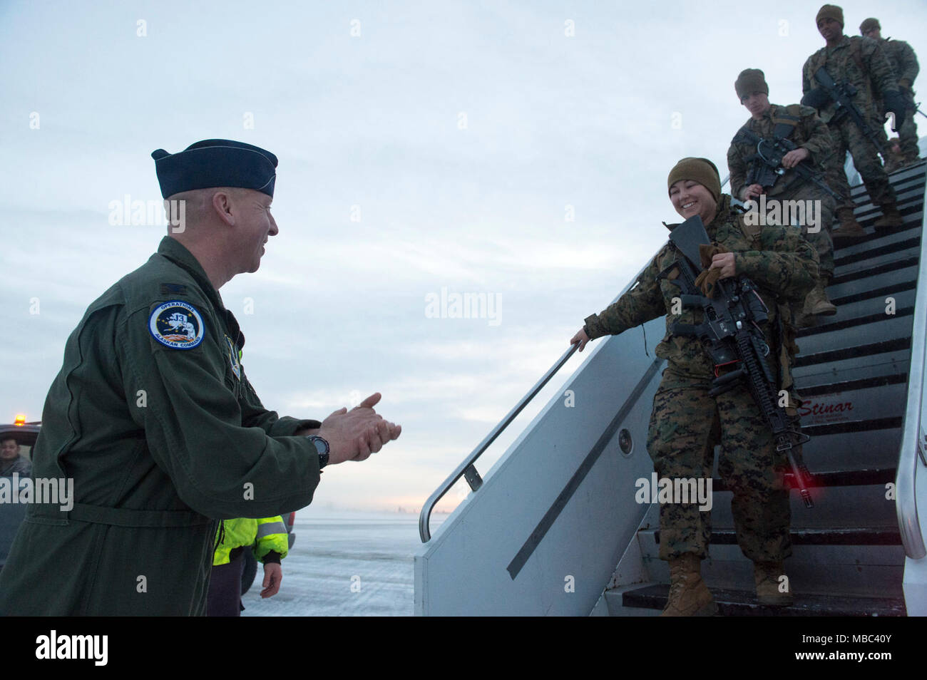 Air Force Col. Mark Schmidt, direttore delle operazioni di comando in Alaska, saluta la visita U.S. Marines con lo scopo speciale Marine-Air-Massa Force-Arctic attività di bordo 18 come essi arrivano a base comune Elmendorf-Richardson, Alaska, Feb 13, 2018. I marines sono a JBER a sostegno di Arctic Edge 2018, una biennale su grande scala, joint-esercizio che prepara e prove il militare degli Stati Uniti è la sua capacità di operare tatticamente nel freddo estremo-Condizioni meteorologiche rilevate in ambienti artici. Sotto l'autorità del North American Aerospace Defense e U.S. Comando Nord, più di 1500 particip Foto Stock