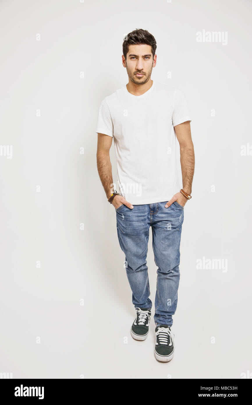 Giovane uomo bianco, T-shirt, jeans e scarpe da ginnastica, studio shot Foto Stock