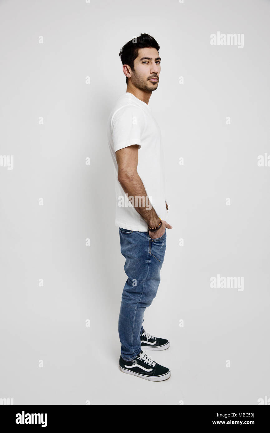 Giovane uomo bianco, T-shirt, jeans e scarpe da ginnastica, studio shot Foto Stock