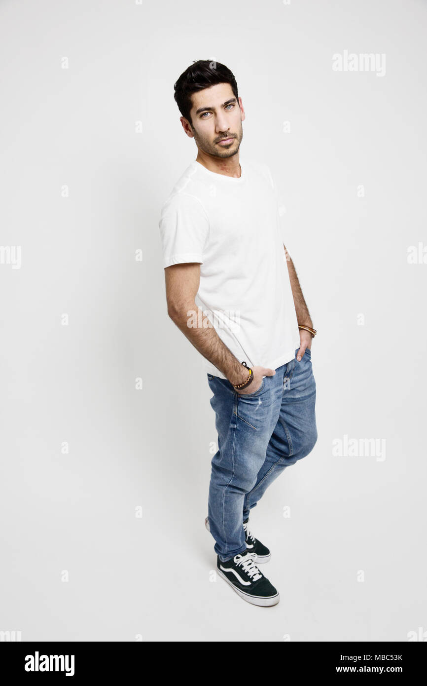 Giovane uomo bianco, T-shirt, jeans e scarpe da ginnastica, studio shot Foto Stock