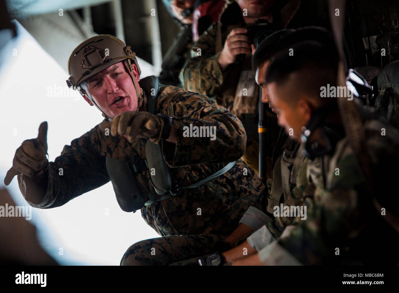 Un U.S. Marine con 3d battaglione di ricognizione, 3d Divisione Marine comunica alla Thai Marines a bordo di un CH-53E Super Stallion al di sopra del distretto di Sattahip nella provincia di Chonburi, Regno di Thailandia, Feb 12, 2018. Marine elicottero pesante Squadron 466 "Wolfpack' supportati helocast formazione con gli Stati Uniti, tailandese e Repubblica di Corea Marine Corps squadre di ricognizione. CH-53E Super Stallion è assegnato a HMH-466, Marine Aircraft Group 16, terzo aeromobile Marina Wing, attualmente distribuito sotto l'unità di distribuzione con il programma Mag-36, 1° MAW, basato fuori di Okinawa, in Giappone. Esercizio Cobra Foto Stock