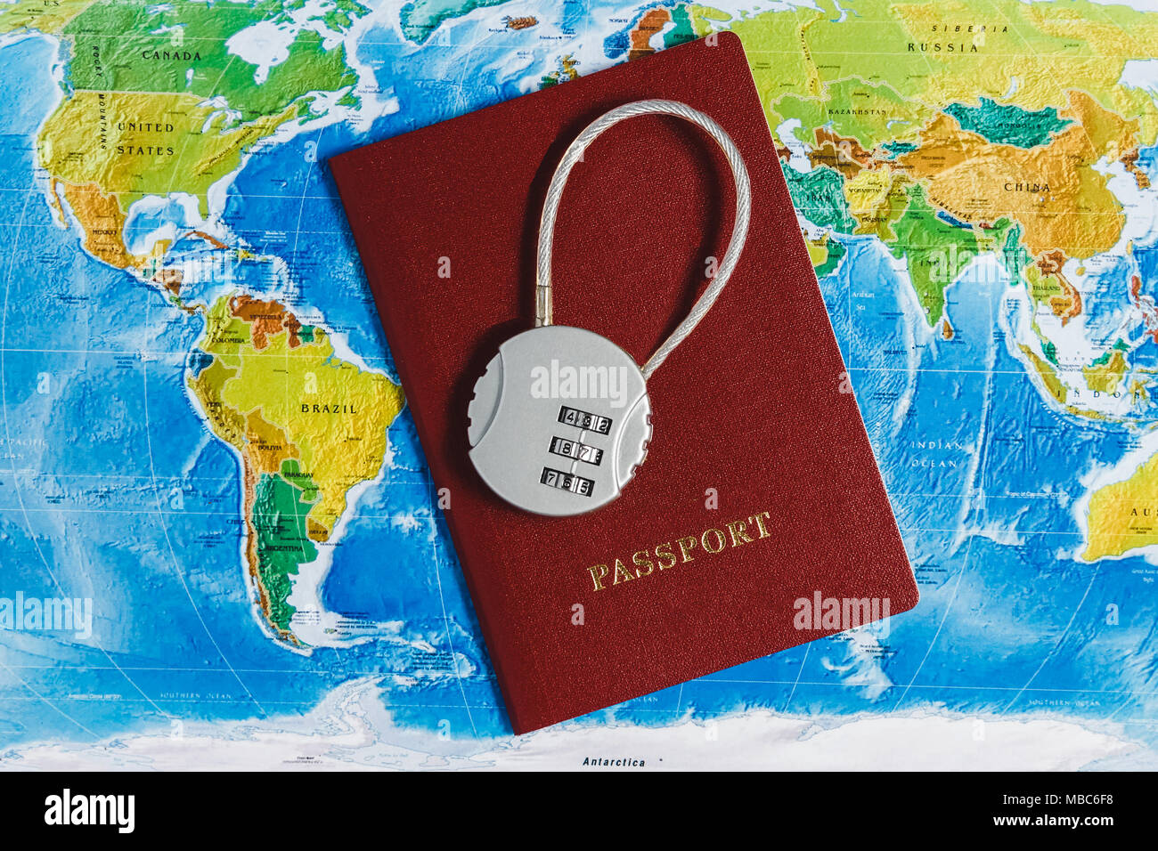 Il blocco di codice sul passaporto rosso sulla mappa del mondo sullo sfondo. Concept-Ban su viaggi, mancanza di Visa. Foto Stock
