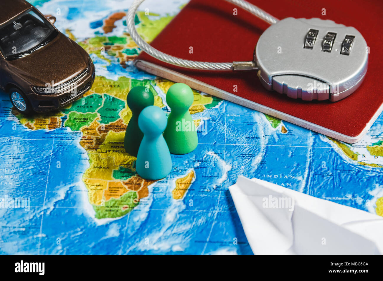 Il blocco di codice sul passaporto rosso, giocattolo auto, uomini, Papercraft piano sulla mappa del mondo sullo sfondo. Concept-Ban su viaggi, mancanza di Visa. Foto Stock