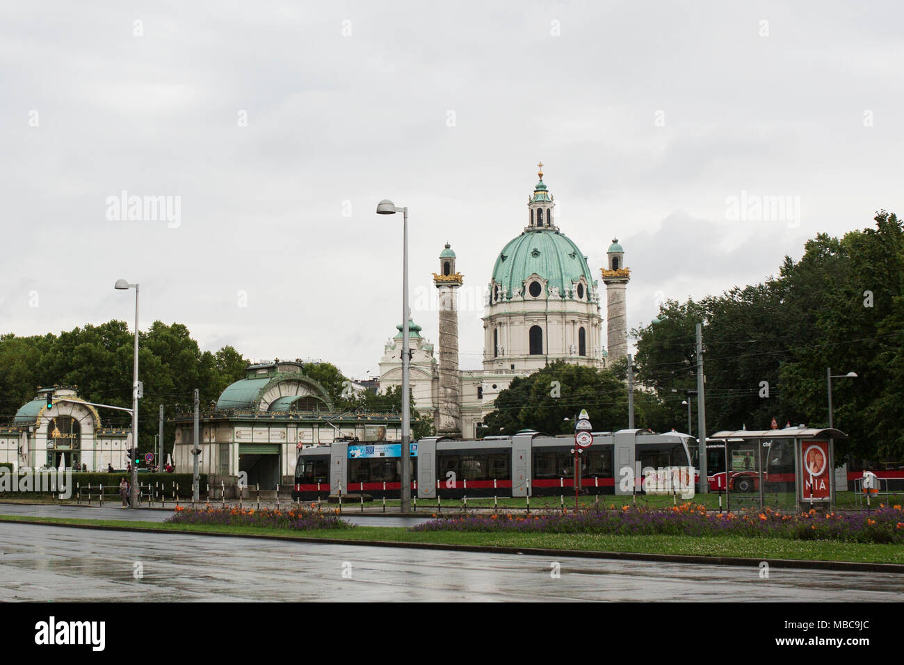 Una vista di Karlsplatz a Vienna con un treno in primo piano la cupola della Karlskirche, e i padiglioni progettati dall'architetto Otto Wagner. Foto Stock