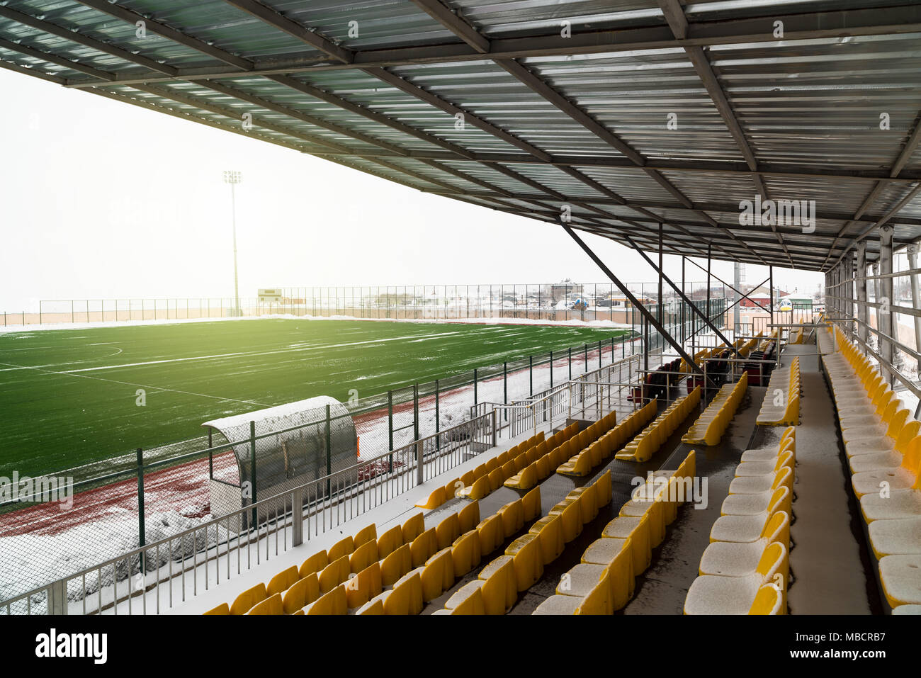 Campo di calcio e il suo giro di tribune sotto neve Foto Stock